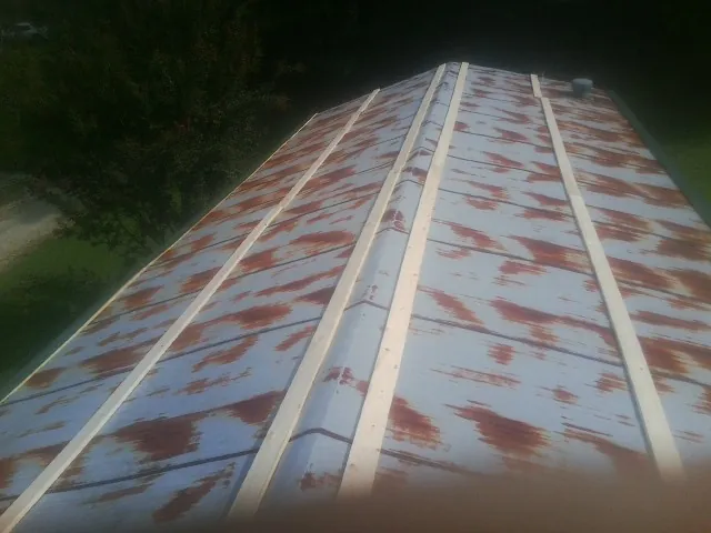 Rusted metal roof panels with new wood purlins before replacement — Storm Damage Roof Repair in Billings by Roofing Brothers